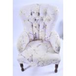 A small contemporary upholstered chair  with button back and floral upholstery.