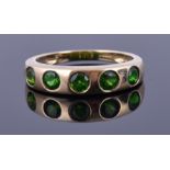 A 9ct yellow gold and Russian chrome diopside ring pavé set with five round cut stones, hallmarked