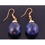 A pair of yellow metal and lapis lazuli earrings each suspended with a large orb of lapis,