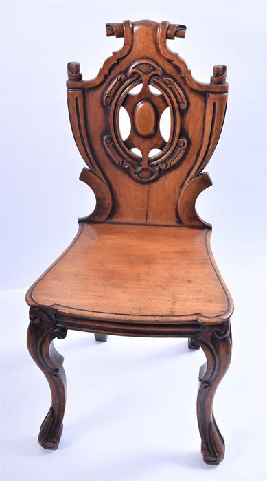 A Victorian mahogany hall chair  with carved and pierced shield-shaped back, solid seat and