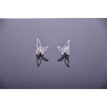 A pair of white gold and diamond butterfly earrings with openwork asymmetric wings set with round