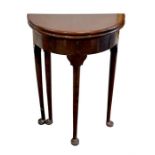 A small Edwardian gate-leg table  The folding circular top supported on four tapering legs with