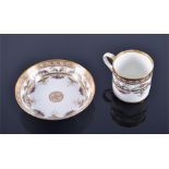 A 19th Century French hand painted coffee can and saucer with trailing puce foliate border and