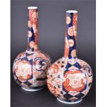A pair of Japanese bottle vases with gilt decoration and patterned with red and blue flowers and