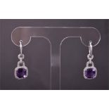 A pair of 14ct white gold, diamond, and amethyst drop earrings each set with a cushion cut