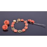 A Chinese yellow gold and coral bracelet set with carved coral flowers connected by chains, together