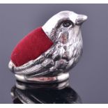 A sterling silver novelty pin cushion in the form of a small bird, with red velvet pin cushion,
