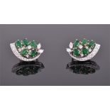 A pair of 18ct white gold, diamond and emerald cluster earrings each set with five oval cut