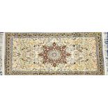 An Eastern ivory ground wool rug centred with a complex medallion, encircled by symmetrical trailing