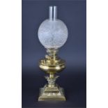A Victorian brass oil lamp the reservoir supported on a corinthian capitol and embossed squared