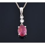 A 14ct white gold, diamond, and ruby drop pendant with oval cabochon ruby beneath two diamonds of