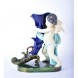 A large Majolica centrepiece in the form of a winged cherub clutching a cornucopia  with brightly