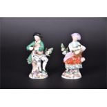 A pair of late 19th century Sitzendorf porcelain figures one carrying a basket of apples and the