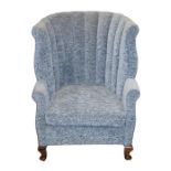 A 20th century mahogany framed rounded tub chair upholstered in a blue floral fabric, with