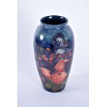 A Moorcroft Finches baluster vase decorated with tubelined birds and fruit on a blue ground,