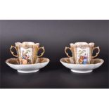 A pair of 19th Century German hand painted ceramic twin handled chocolate cups and saucers decorated