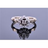 A diamond flowerhead ring, centred with a round brilliant-cut diamond weighing approximately 0.