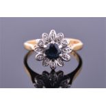 An 18ct yellow gold, diamond, and sapphire floral cluster ring set with a round cut sapphire, the