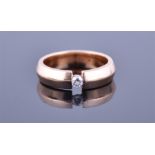 A 14ct rose gold and diamond ring with round cut suspension set diamond of 0.10 carats, within
