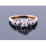 An 18ct yellow gold and diamond ring set with three round cut diamonds, the larger central stone