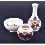 Three pieces of Moorcroft comprising two small vases, and a bowl, all decorated with red flowers