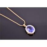 An impressive 18ct yellow gold, diamond and tanzanite pendant of oval form, set with an oval cut
