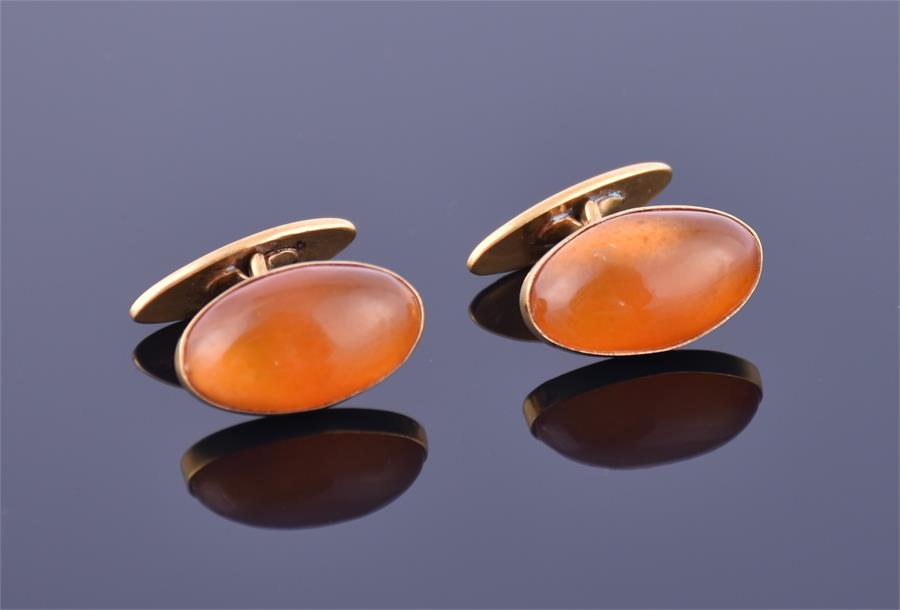 A pair of Russian amber and gold cufflinks each of oval cabochon form, set in yellow metal stamped