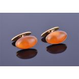 A pair of Russian amber and gold cufflinks each of oval cabochon form, set in yellow metal stamped