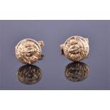 A pair of 18ct yellow gold cufflinks of circular form, having raised decoration in the form of