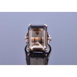 A 9ct yellow gold and smoky quartz set with an emerald cut quartz in an ornate mount, size L