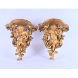 A pair of 19th century carved gilt wood and gesso cherub wall brackets formed as cherubs