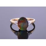An unusual 9ct yellow gold and ammolite ring set with an oval tri-coloured ammolite, flanked by