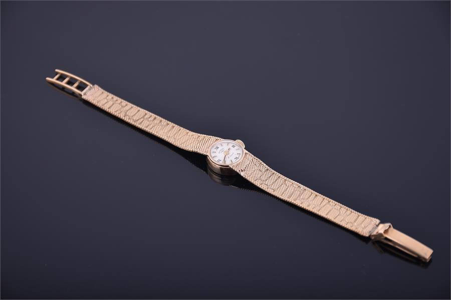 A ladies 9ct gold Rotary wristwatch with mechanical hand wound movement, on a bark effect mesh