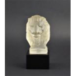 A frosted glass car mascot in the form of a lion's mask. Supported on a black glass cube base. 18 cm