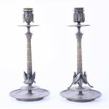 A pair of decorative bronze candlesticks  each in the form of an ancient Egyptian column.