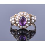 A Victorian yellow gold, amethyst, and seed pearl ring centred with an oval cut amethyst within a