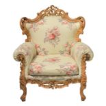 An Edwardian style open arm chair with scrolled and pierced wooden frame, upholstered in a colourful