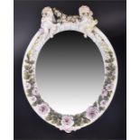 A charming late 19th century Sitzendorf dressing table mirror of oval form, surmounted with two