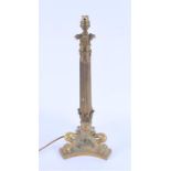 A large brass column electric table lamp the fluted stem supported on a tripod base with paw feet