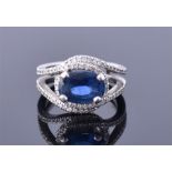 A platinum, diamond, and sapphire ring the oval cut sapphire of approximately 2.50 carats, within