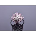 A white metal, diamond, and ruby cluster ring centred with a round brilliant cut diamond 0.30cts,