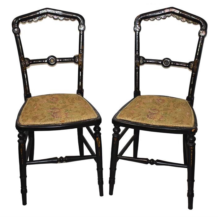 A pair of Victorian black lacquered and mother-of-pearl inlaid chairs the domed openwork backs
