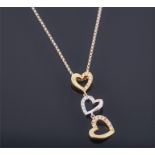An 18ct white and yellow gold heart-shaped pendant suspended with three hearts set with diamonds, on