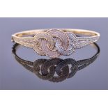An 18ct white, yellow, and rose gold bangle the inter-connected circles pavé set with diamonds,
