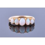 An 18ct yellow gold and opal ring set with five graduated oval cabochon opals, size K 1/2