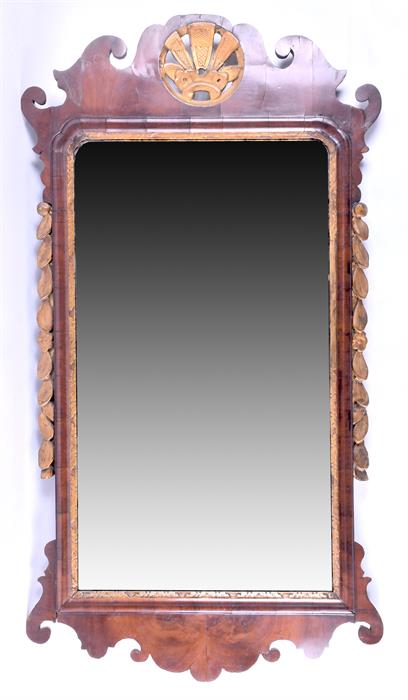An 18th century Queen Anne style walnut and gilt pier mirror the shaped frame crested with an