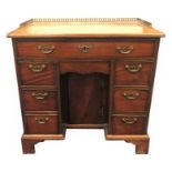 A small Georgian mahogany knee-hole desk  The central hinged door flanked by six small square