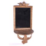 A small Victorian gilt wood wall sconce, backed by a framed mirror decorated with applied fern