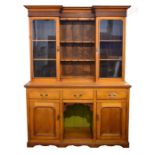 A large Victorian pale oak dresser the top with a pair of glass doors and plate shelves, upon a base
