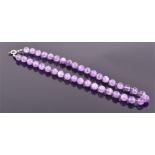 An amethyst beaded necklace the faceted round beads approximately 9 mm diameter, with silver